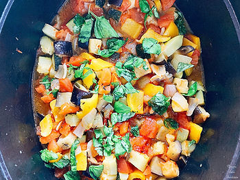 Zucchini, eggplant, yellow bell pepper, onion, garlic, tomato, bay leaf, thyme, rosemary, and basil in a pot