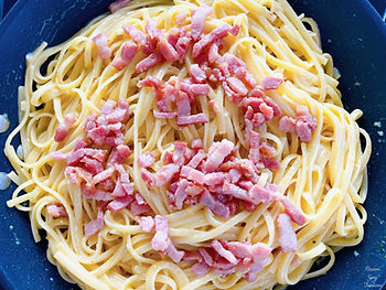 Spaghetti in a frying pan, parmesan and egg sauce, bacon