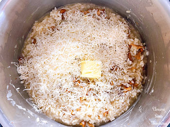 Onions, rice, mushrooms (chanterelles), parmesan cheese and butter in a pot