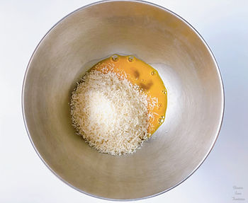 Parmesan cheese, eggs and egg yolks in a bowl