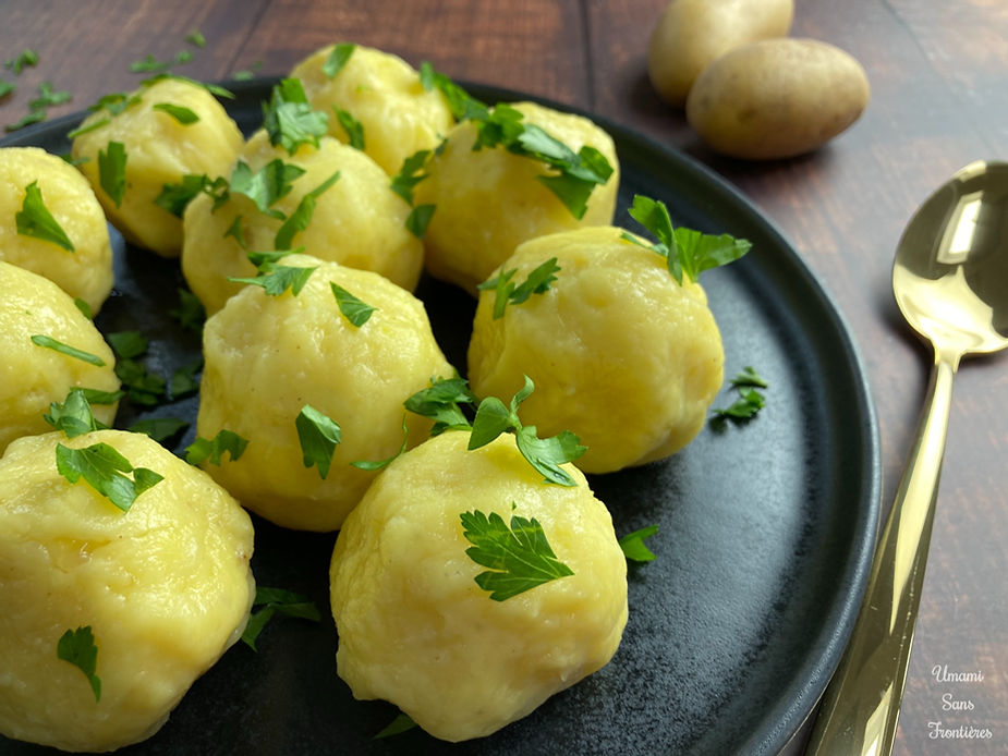 Potato dumplings, parsley, spoon and potatoes on a plate