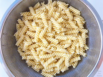 Pasta in a colander, olive oil