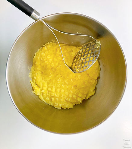 Potatoes in a bowl, masher