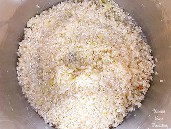 Onions, rice and white wine in a pot