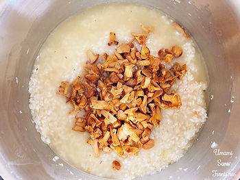 Onions, rice, stock and mushrooms (chanterelle) in a pot