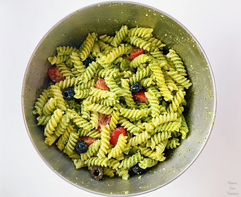 Bowl of pasta with tomatoes, black olives and genovese sauce