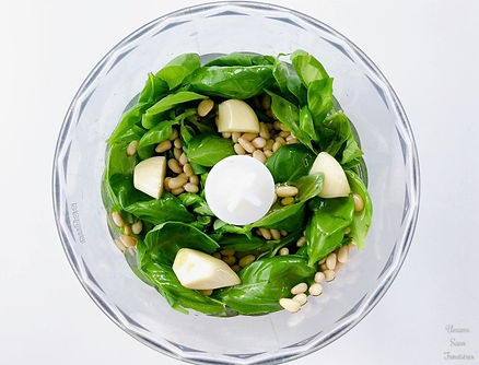 Basil leaves, garlic, pine nuts, and olive oil in food processor