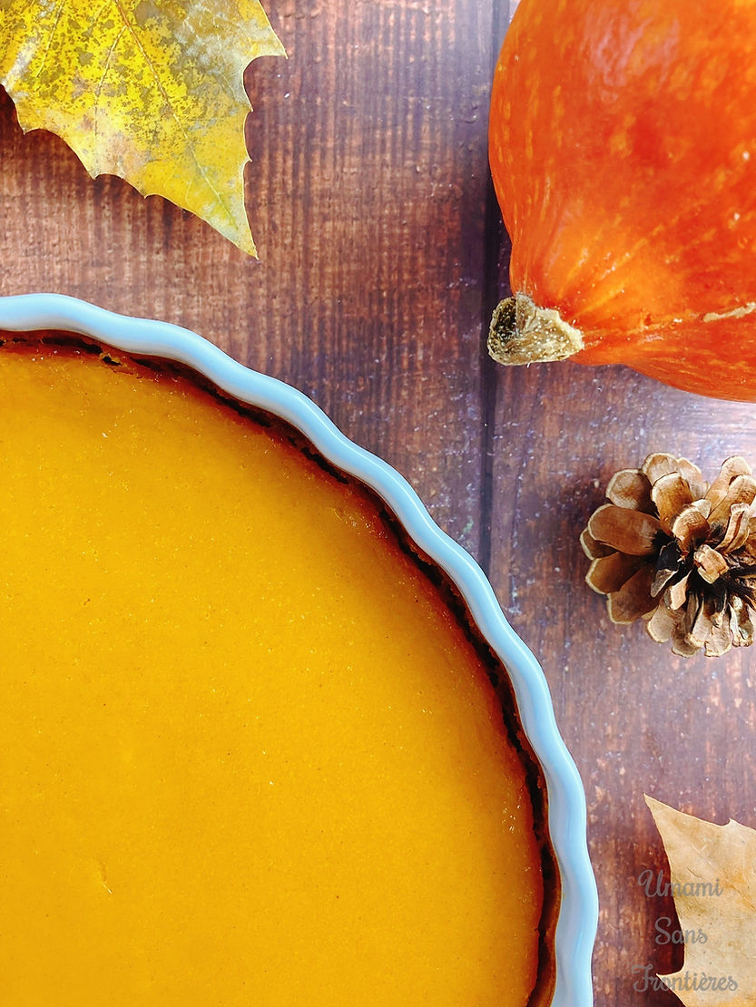 Biscuit dough pumpkin tart in a heat-resistant dish, pine cones, pumpkin, and autumn leaves