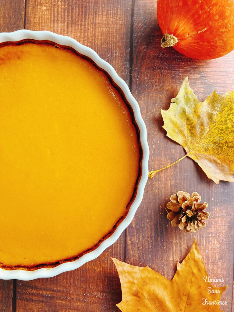 Biscuit pastry pumpkin tart in a heat-resistant dish, pumpkin, autumn leaves and pine cones