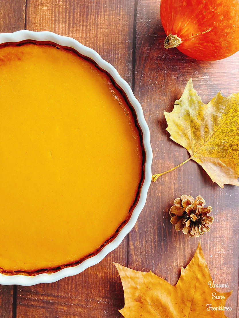 Biscuit pastry pumpkin tart in a heat-resistant dish, pumpkin, autumn leaves and pine cones