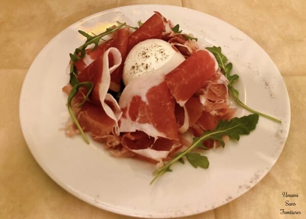 appetizer of arugula prosciutto and mozzarella
