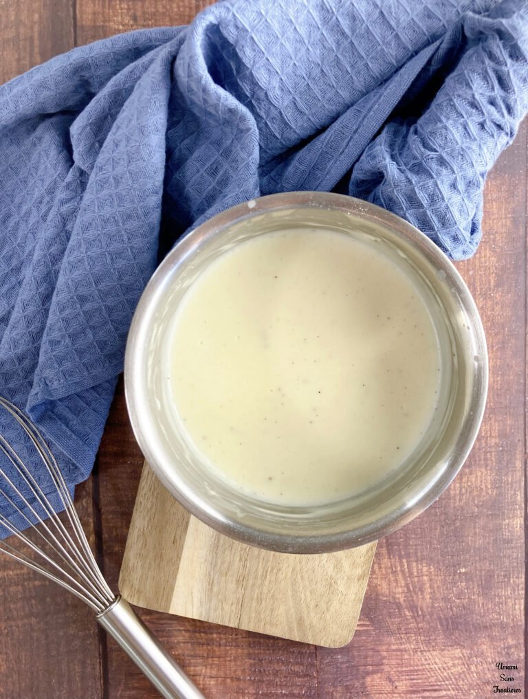 Bechamel bechamel sauce in a pot kitchen towel whisk wood plate