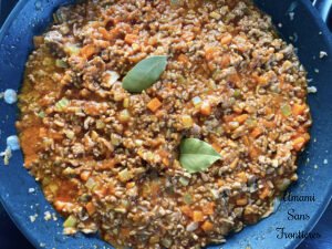Bolognese Vegetables bacon ground meat bay leaves and tomato puree in a flying pan