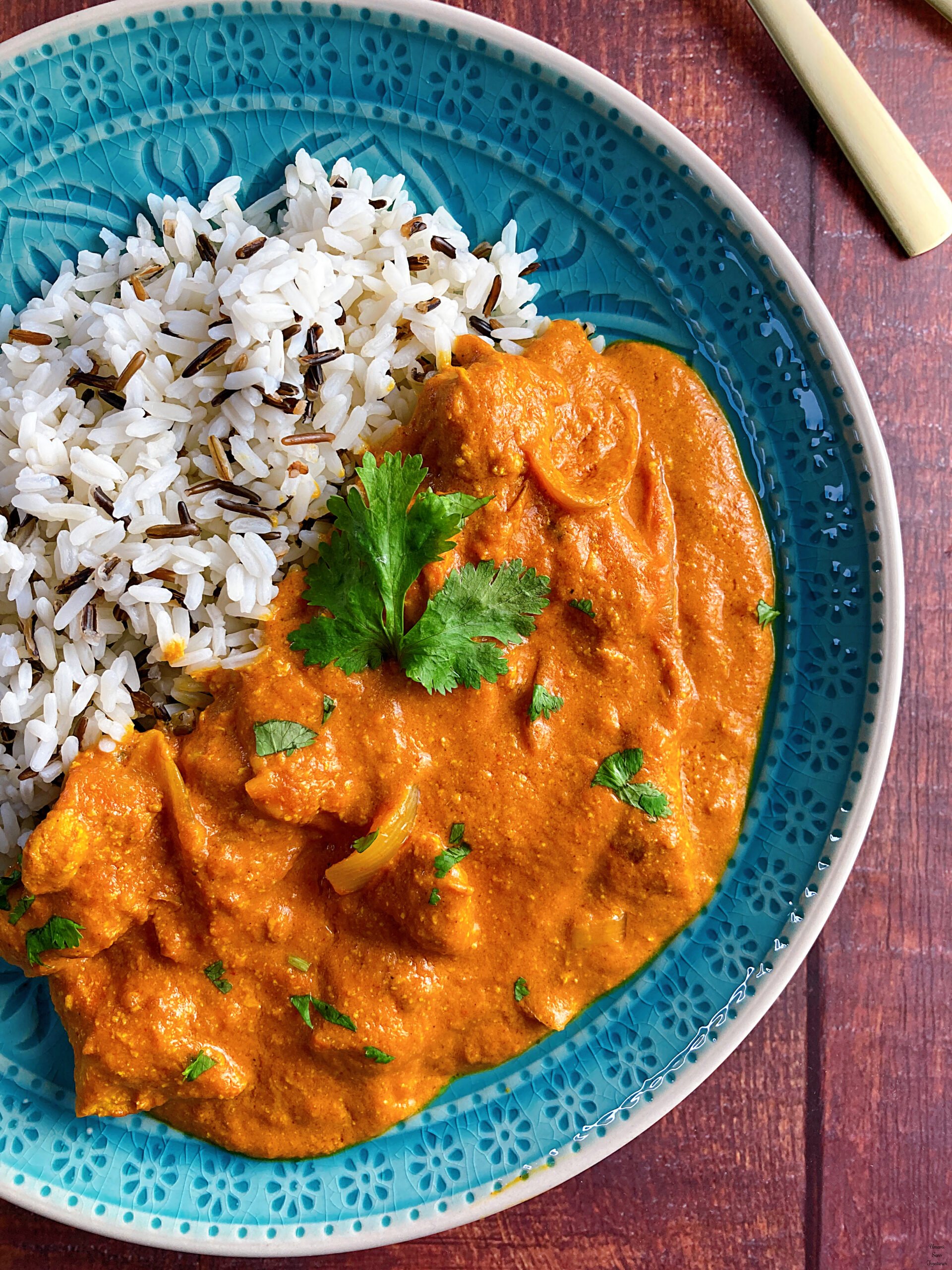 Butter chicken curry butter chicken curry coriander wild rice in a plate