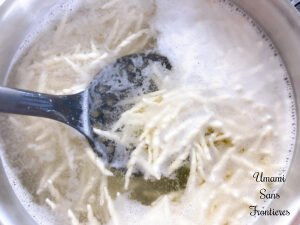 Pasta Pesto past torofie a slotted spoon boiled water in a pot