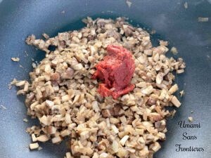 Pasta alla boscaiola cremosa tomato paste mushroom onion in a frying pan