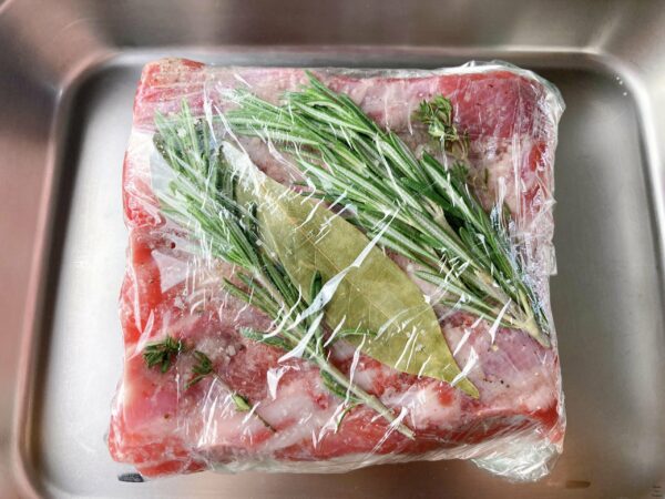 Petit salé aux lentilles pork belly herbs plastic wrap