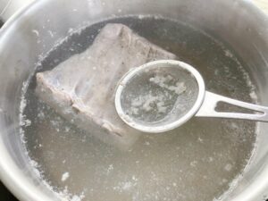 Petit salé aux lentilles pork belly in hot water in a pot