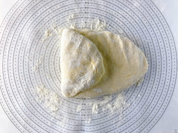 Pizza Quattro Formaggi dough folded one side toward the center