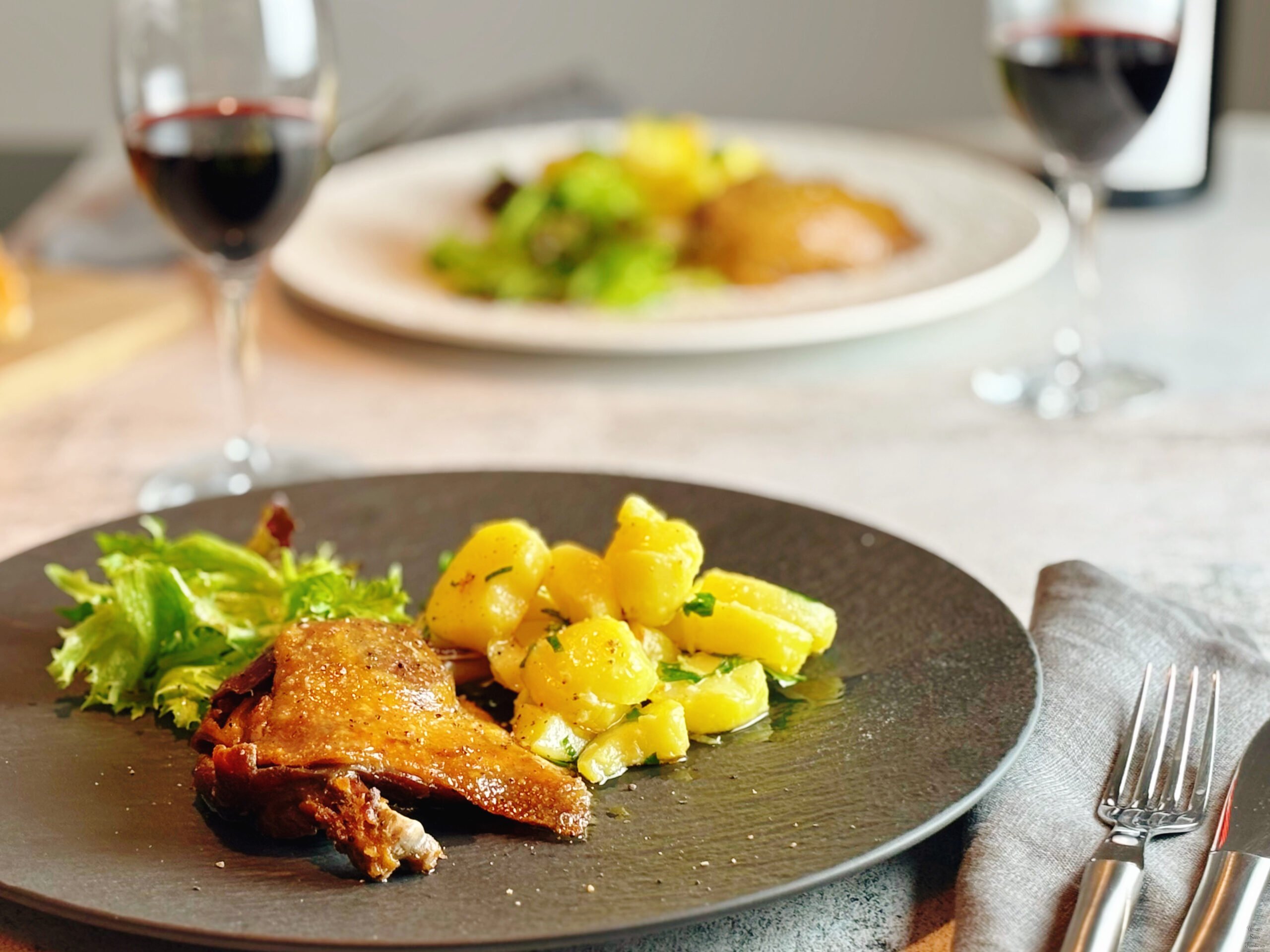 Oven-Baked French Duck Confit with Sautéed Potatoes red wine fork knife