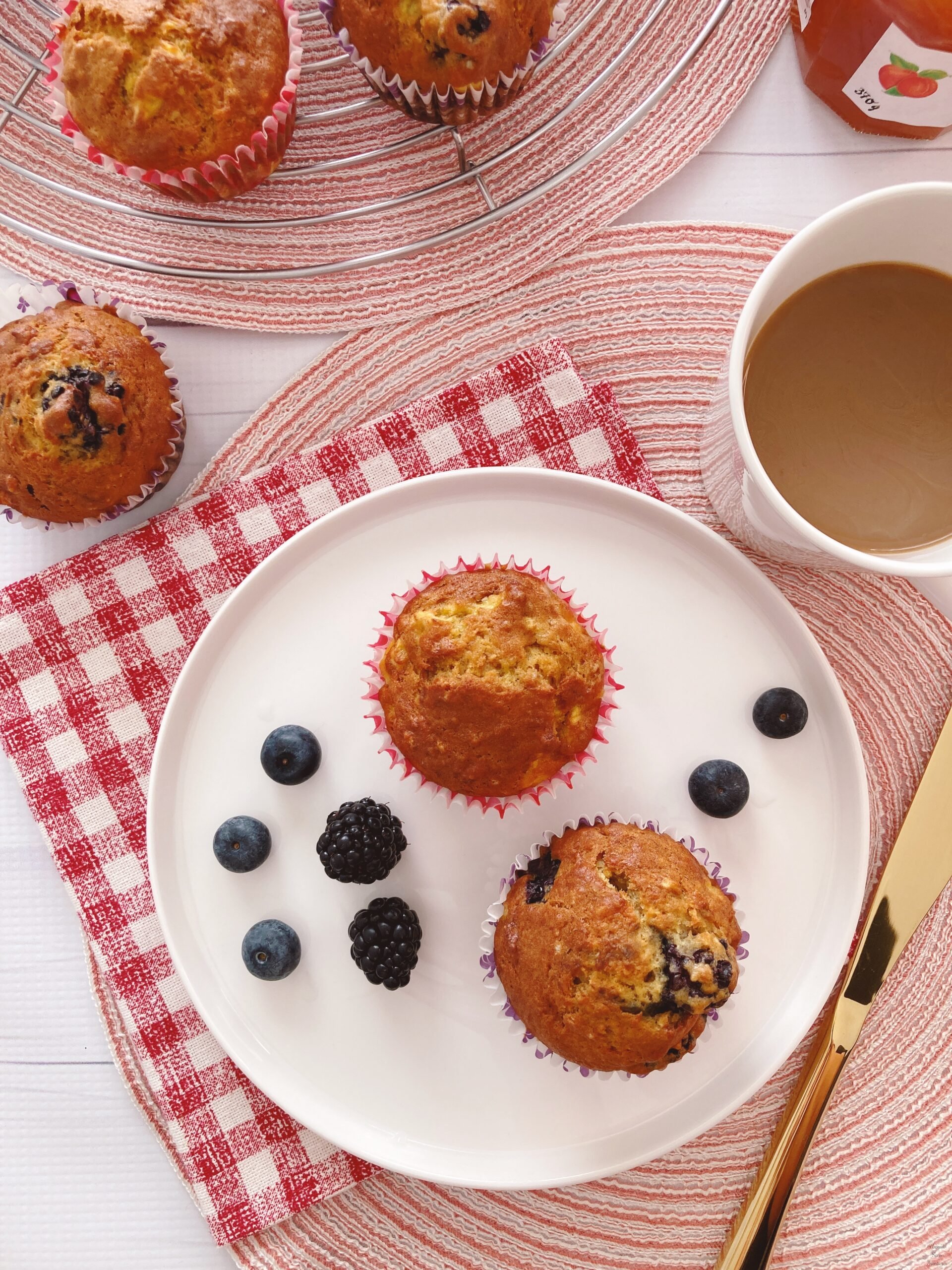 2 muffins berries on the plate coffee jam knife