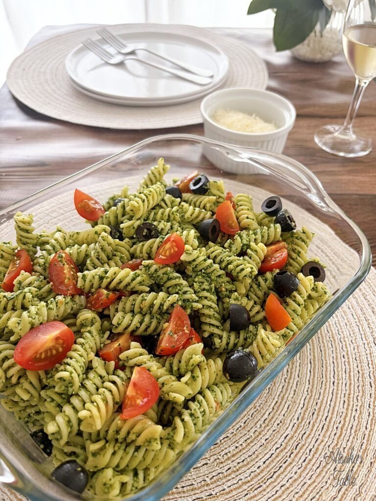 chilled tomato olive pasta with pesto cheese plates forks