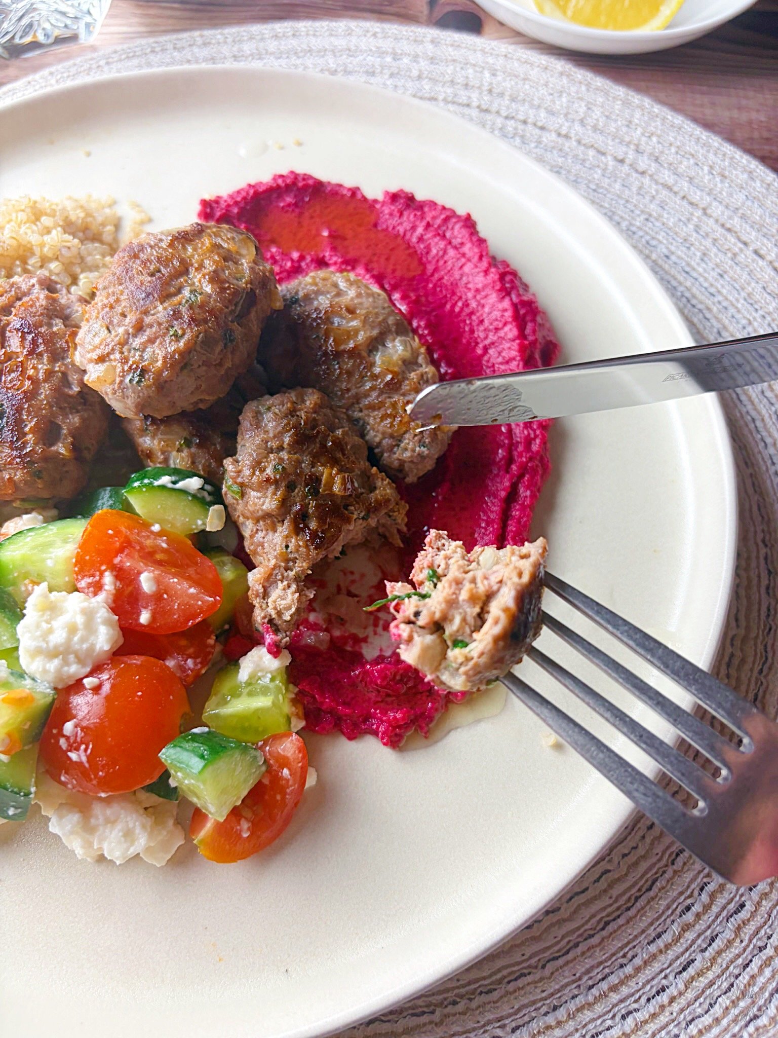 fork knife piece of kofta beet hummus