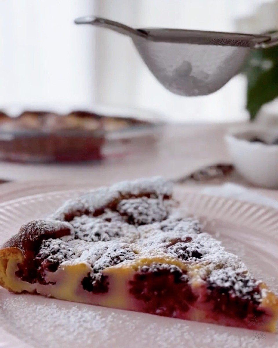 a piece of blackberry clafoutis icing sugar